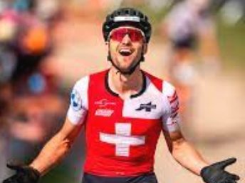 Ciclista con maillot suizo celebra con los brazos levantados tras una carrera